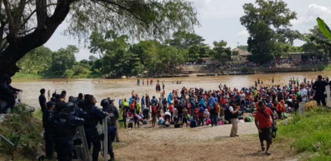 Migrantes  forman cadena humana para cruzar el Río Suchiate