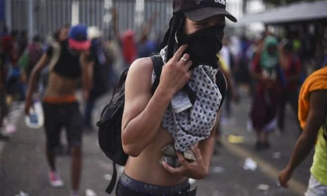 Caravana migrante se enfrenta con policía en frontera Guatemala-México
